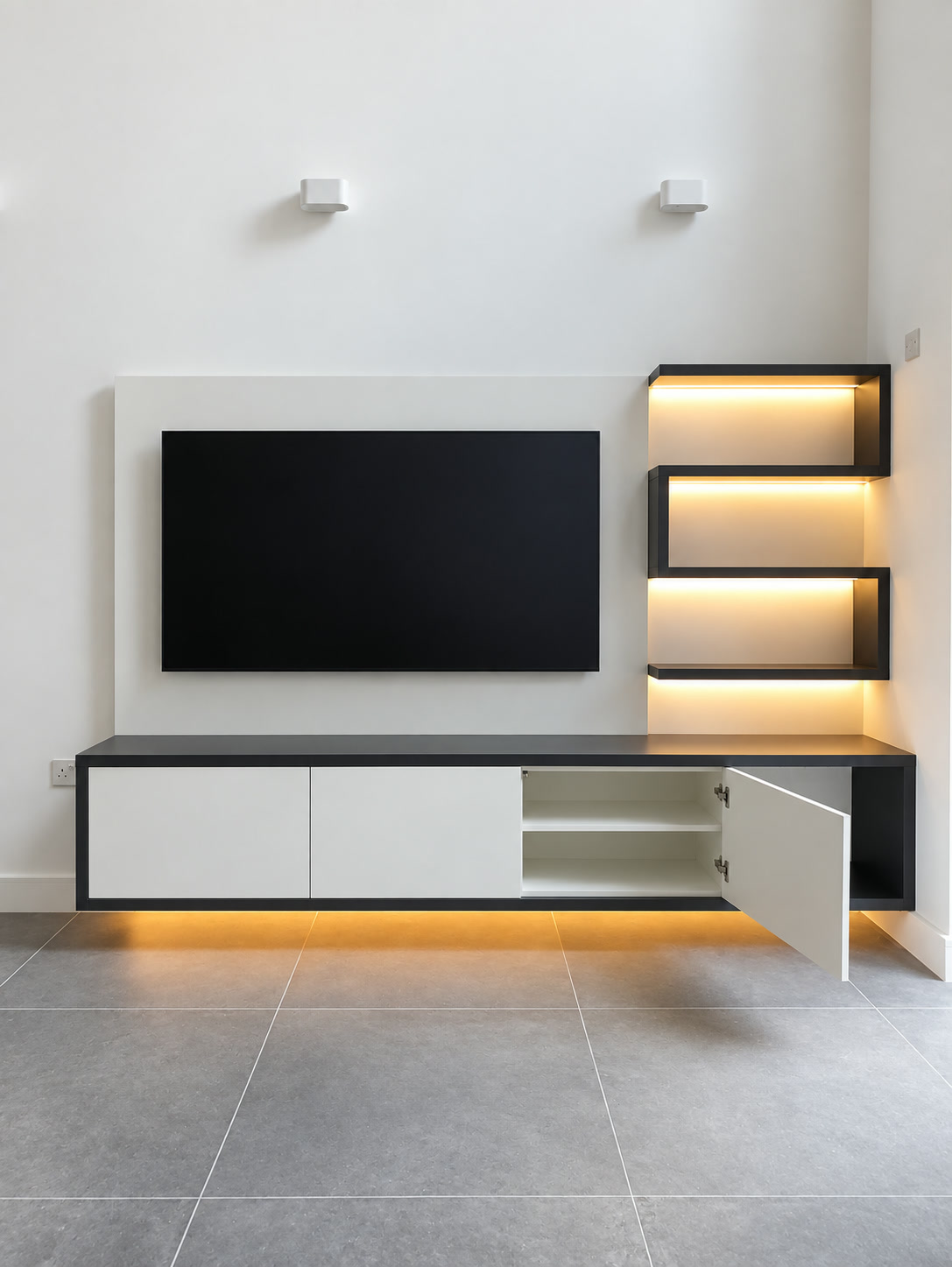 Open bespoke TV cabinet showing internal shelves and accessible storage beneath a wall-mounted television