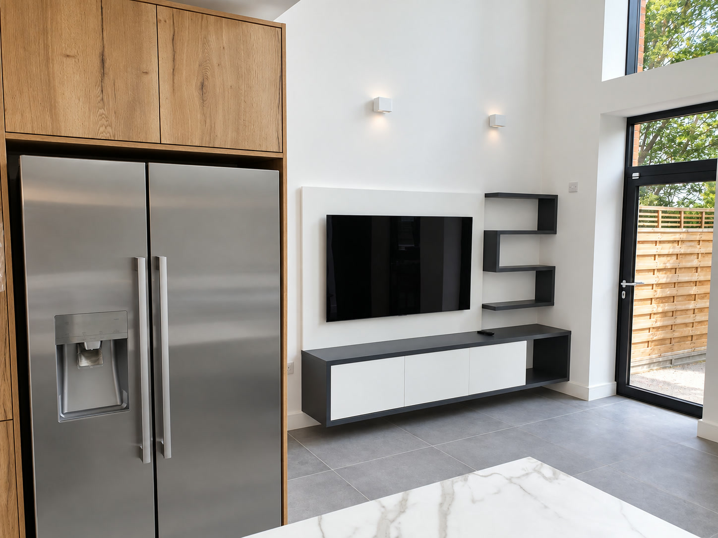 Bespoke fitted TV cabinet viewed in context with an adjoining contemporary London kitchen