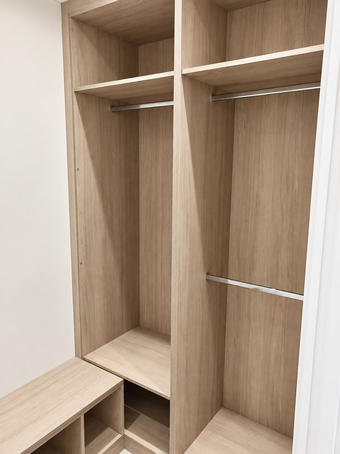 Light wood walk-in wardrobe corner with long hanging, double hanging and a low shoe bench