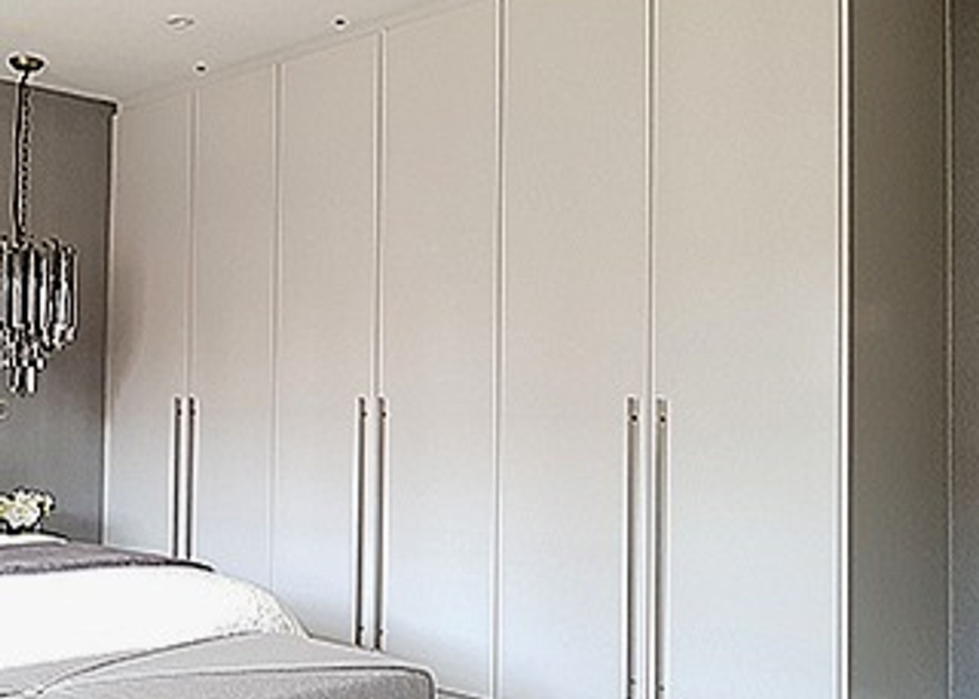 Completed light-grey hinged fitted wardrobe with framed panel doors