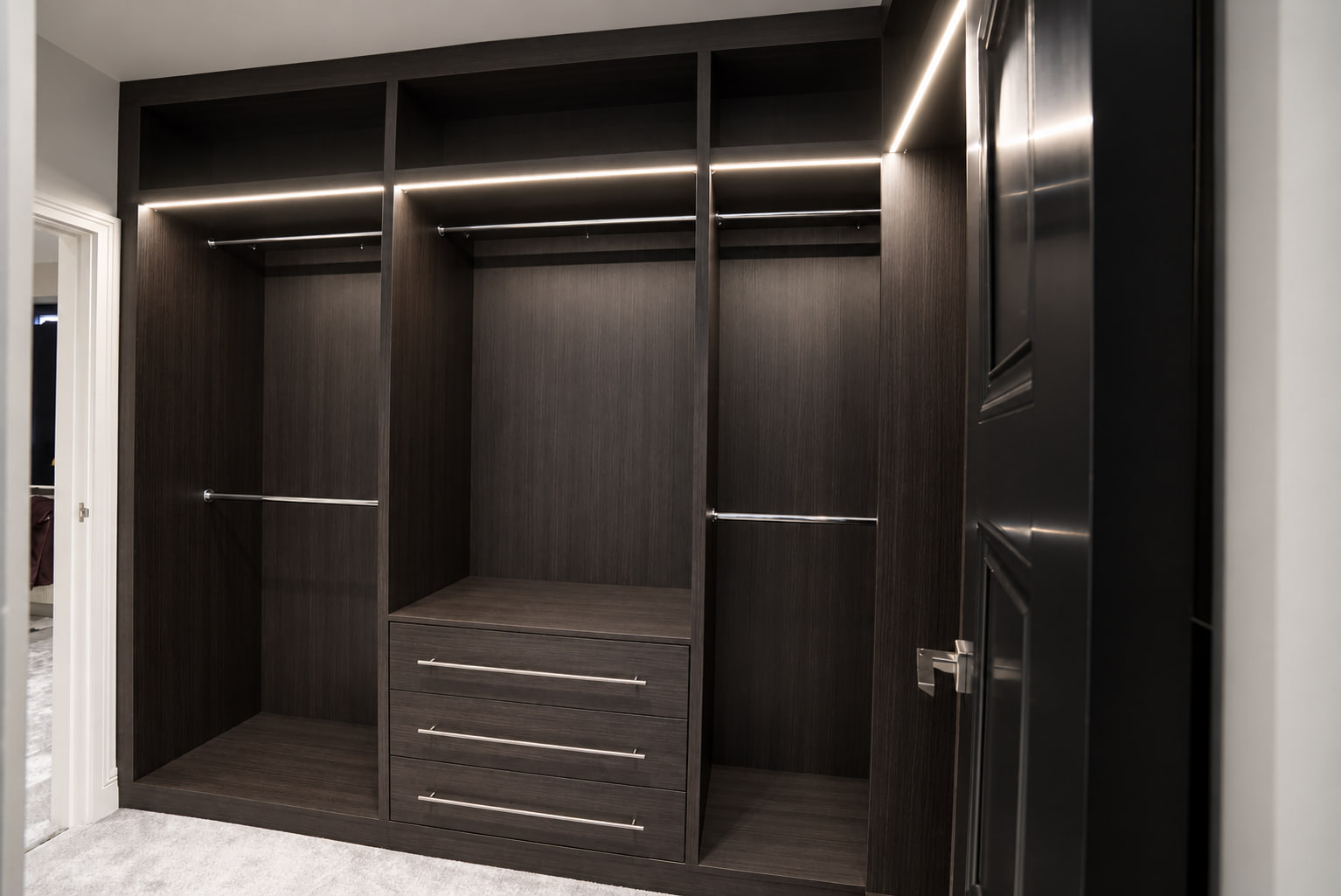 Dark woodgrain LED-lit walk-in wardrobe wall