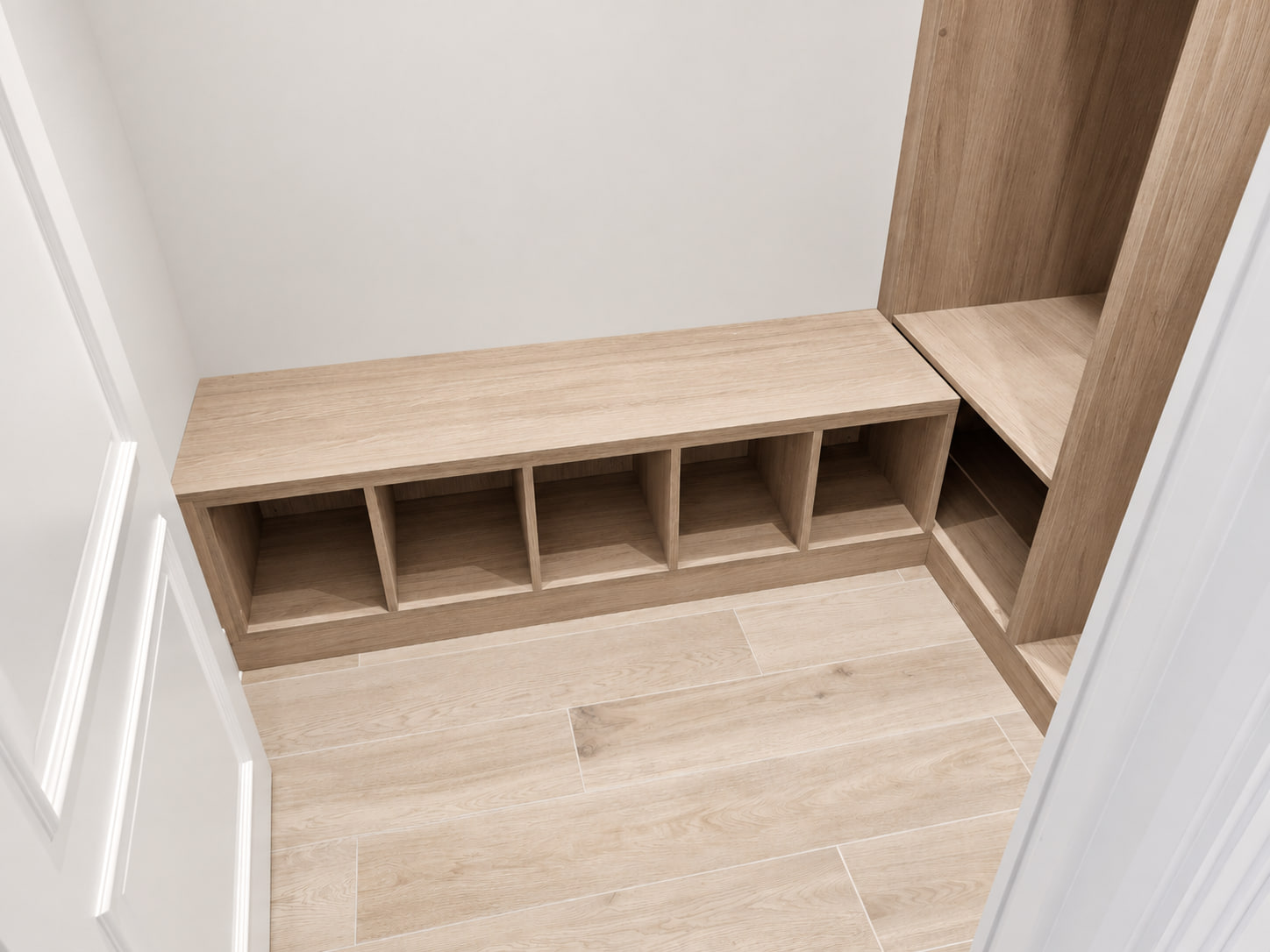Shoe bench and cubbies in a light woodgrain walk-in wardrobe