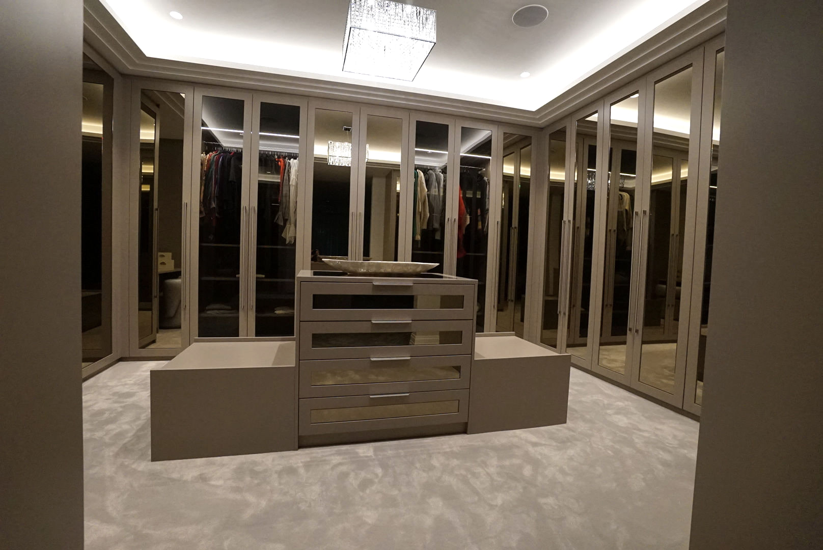 Taupe mirrored dressing room with a central island