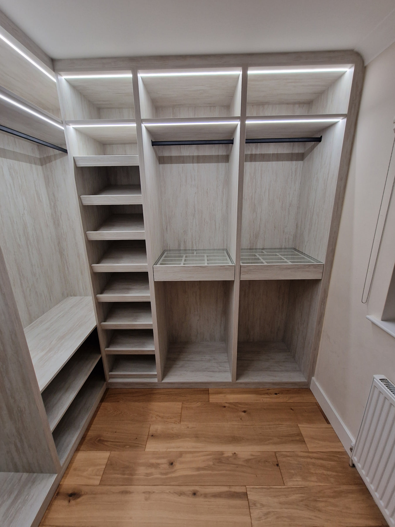 Open walk-in wardrobe with shelves, hanging rails and drawers